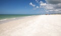 Blue sky over white sand and green beach grass of Tigertail Beach