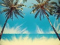 Blue sky and palm trees view from below, vintage style, tropical beach and summer background Royalty Free Stock Photo