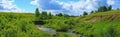 Blue sky panorama with clouds over tops of trees