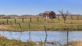 Saskatchewan landscape with old shed, tree, fence lines and spring water run off slough Royalty Free Stock Photo