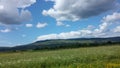 Blue sky, puffy clouds and green terrain Royalty Free Stock Photo