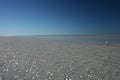 Blue sky and shell speckled beach melt at eighty mile beach Western Australia