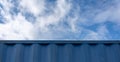Blue sky and side wall of marine cargo metal container, blue background Royalty Free Stock Photo