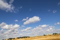 Blue sky with small clouds under agriculture golden straw field on sunny summer day Royalty Free Stock Photo