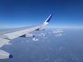 Blue sky and small scattered clouds from airplane window