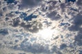 Blue sky with the sun behind the clouds. The cloudy sky hides the bright sun. A beautiful photo of nature. Glorious sunny day Royalty Free Stock Photo