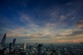 Blue Sky Sun behind Clouds over Modern Cityscape at Sunset