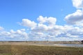 Blue sky. Thick clouds low over the ground. Forest in the distance. Green field of grass. The Kostroma River. A large field