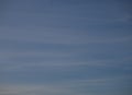 Blue sky with thin white stripes of clouds background. Beautiful panoramic sky with upcoming twilight Royalty Free Stock Photo