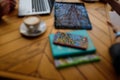 Blue sky and trees reflection in smartphone and tablet on unfocused wooden cafe table. Unfocused cappuccino cup, laptop on Royalty Free Stock Photo