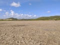 Panoramic photo of dry salt pans of ocher color. Blue sky with tropical clouds and mountains with vegetation. Martinique, French Royalty Free Stock Photo