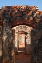 BLUE SKY VISIBLE ABOVE SUCCESSIVE DOOR ENTRANCES CONNECTING THE INNER CHAMBER OF A ROOFLESS FORT COMPLEX IN RUINS