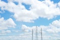 Blue sky and white cloud with high voltage transmission towers and power line Royalty Free Stock Photo