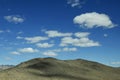 Blue sky with white clouds on bare mountain