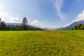 Blue sky with white clouds and field with green grass, forest an Royalty Free Stock Photo