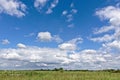 Blue sky with white clouds over a green field