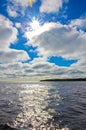 Blue sky and white clouds over Lake Ladoga. Bright sun with rays and highlights