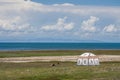 The blue sky and white clouds beside Qinghai Lake, as well as some tents and prayer flags on the grassland Royalty Free Stock Photo