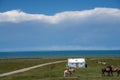 The blue sky and white clouds beside Qinghai Lake, as well as some tents and prayer flags on the grassland Royalty Free Stock Photo