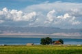 The blue sky and white clouds beside Qinghai Lake, as well as some tents and prayer flags on the grassland Royalty Free Stock Photo