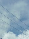 blue sky with white clouds stretched by electric cables Royalty Free Stock Photo