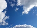 Blue sky with white cumulus clouds on a sunny clear day. Natural background for later design. Prediction of weather on the circula