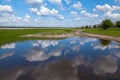 Blue sky with white fluffy clouds and lush green grass reflected in the river. Ukraine Royalty Free Stock Photo