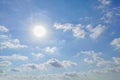 Blue sky with white fluffy clouds with the sun shining in the summer season. Royalty Free Stock Photo