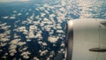 Blue Sky and white fluffy Clouds View from above through airplane's window at sunrise Royalty Free Stock Photo