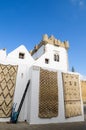 Blue sky and white house with carpets - Asilah, Morocco.