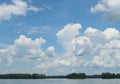 Blue sky with white puffy clouds over a fresh water lake Royalty Free Stock Photo