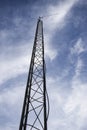 LOOKING UP AT TALL ANTENNA TOWER AGAINST BLUE SKY