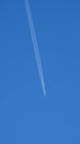 Blue sky, at the zenith, the departing plane leaves a white trail from the engines. Royalty Free Stock Photo