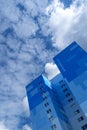 Blue skyscraper with rectangular color fields pattern abstract painted mural art in blue gradient of sky in front of summer cloudy