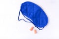 Blue sleep mask and orange ear plugs Royalty Free Stock Photo