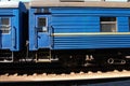 A blue sleeping train wagon at a railway station waiting for passengers. Side view. Railroad travel concept