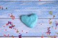 Blue slime clod in heart form on blue wooden background