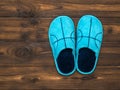 Blue Slippers on the dark brown wooden floor. The view from the top. Flat lay. Royalty Free Stock Photo