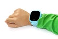 Blue smart digital watch on boy hand with green sleeve. Modern children technologies. GPS tracker for kids, child tracking and Royalty Free Stock Photo