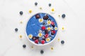 Blue smoothie bowl or nice cream made of frozen berries, banana and coconut with chamomile flowers Royalty Free Stock Photo