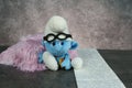 Blue smurf with glasses on concrete table