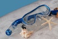 Blue snorkel mask with shells on the sand and blue background Royalty Free Stock Photo