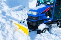 Blue snowplow removes snow, winter, road after snowfall, vertical
