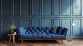 Blue sofa against blue panelled wall with lamp on wooden floor and plant in vase