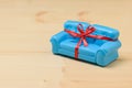 Blue sofa with red ribbon on light wooden background. Unusual gift