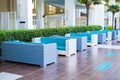 Blue sofas in a row outdoor in the lobby hotel, background of neat green spaces