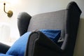 Blue Soft Chair With Pillow, High Back Reading Lamp Above The Head. Living Room Interior. Sofa With Pillows