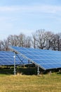 Blue solar panels photovoltaics power station with trees in background Royalty Free Stock Photo
