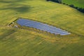 Blue solar panels surrounded by beautiful green fields - bird eye perspective