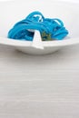 Blue spaghetti, black place setting